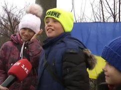 В Изюме дети с украинским флагом ежедневно поздравляют военных
